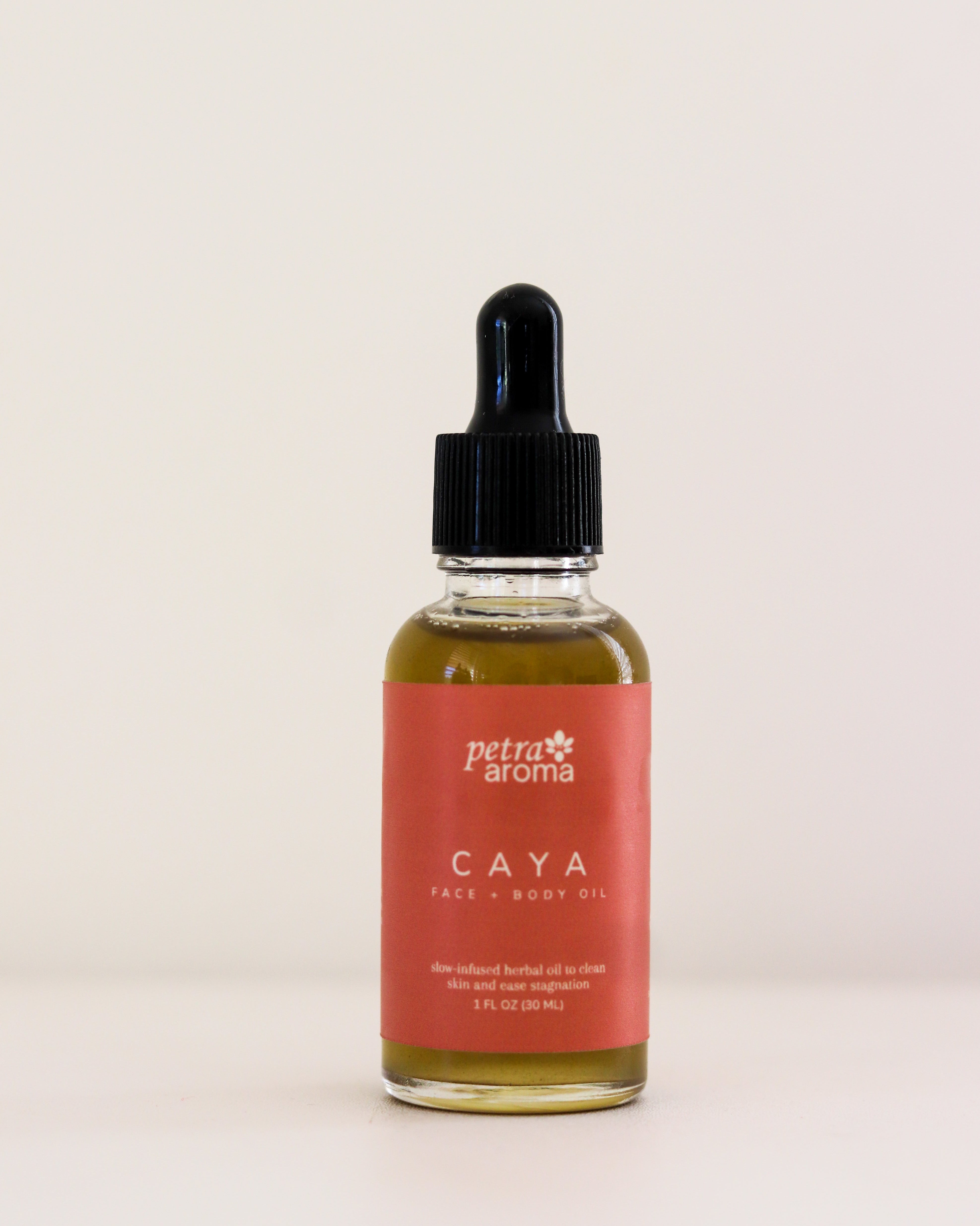 Bottle of Petra Aroma Caya oil with a dropper on a light beige background