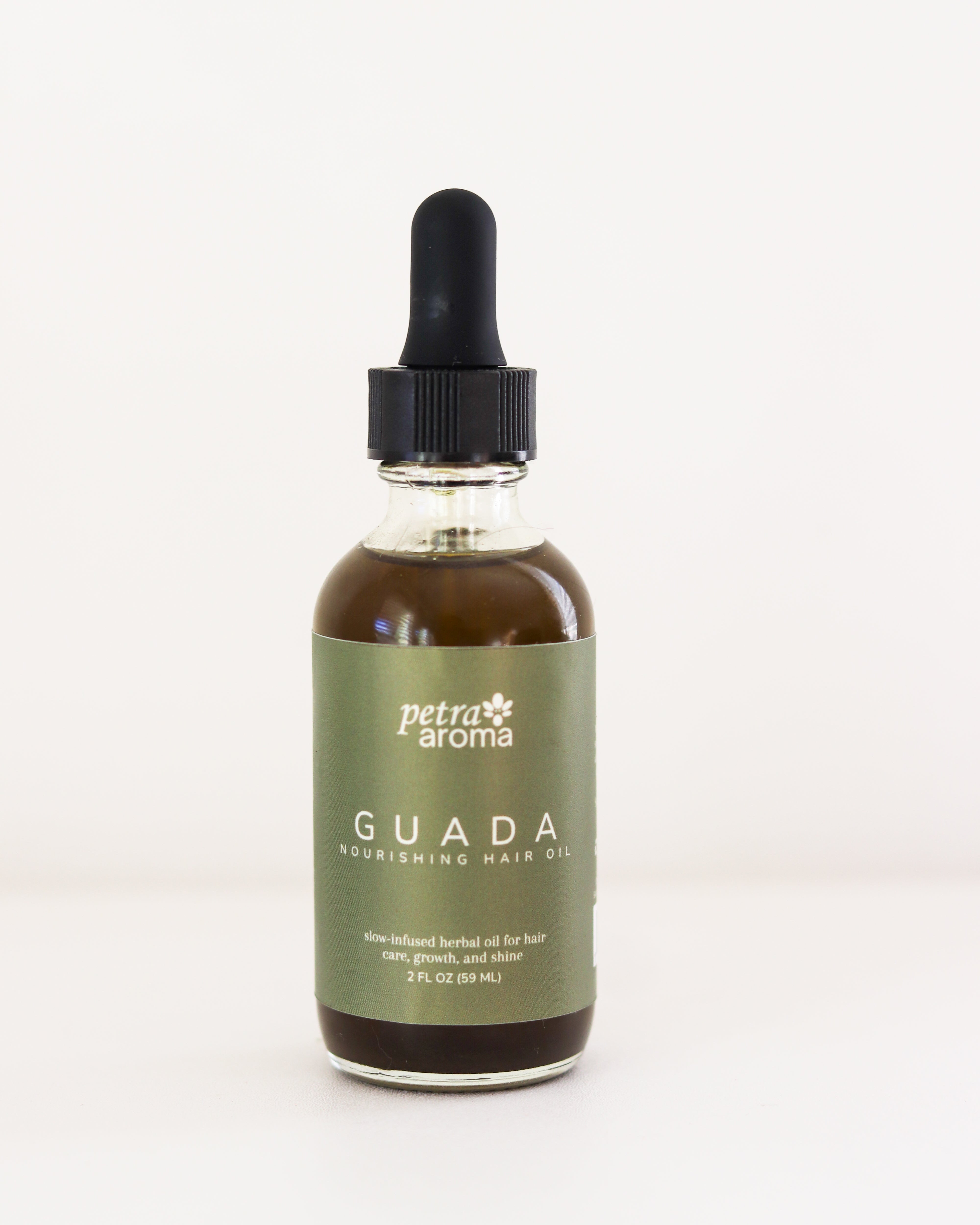 Bottle of Petra Aroma GUADA nourishing hair oil on a white background