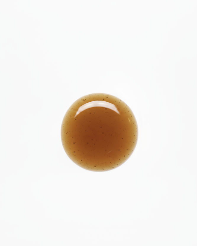 Close-up of a round, brown liquid droplet on a white background