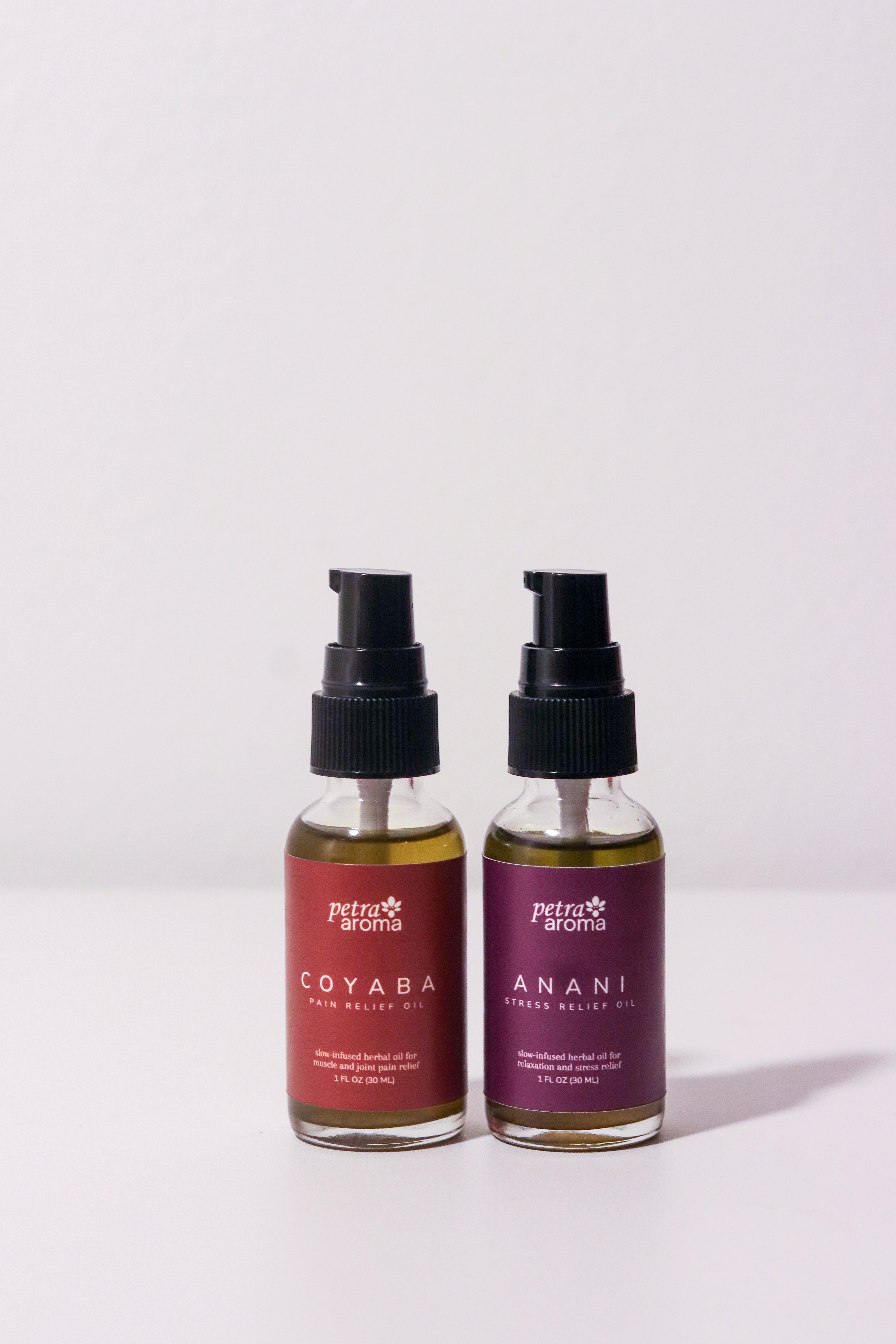 Two bottles of Petra Botanics hair oils on a white background