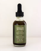 Bottle of herbal oil with dropper on a light background